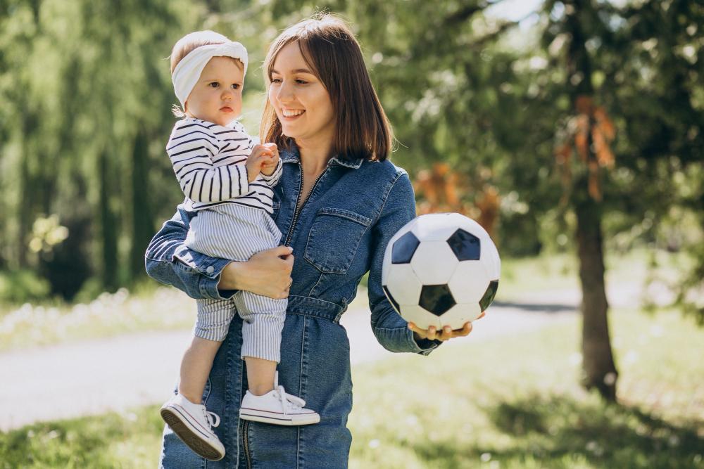 mother-with-baby-girl-playing-with-ball-park